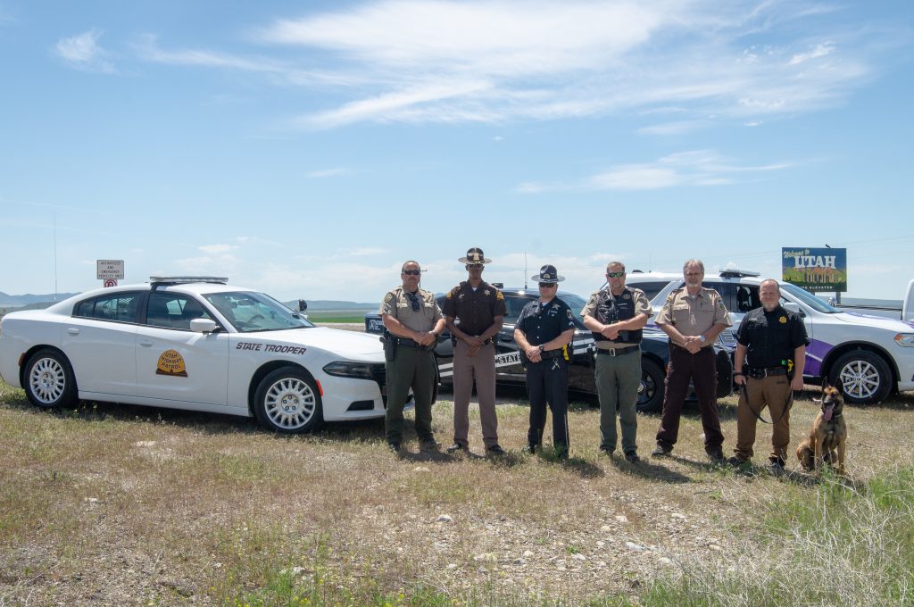 Officers from multiple different agencies stand by their vehicles at the Utah-Idaho border as part of the Click It or Ticket Border to Border Enforcement effort.