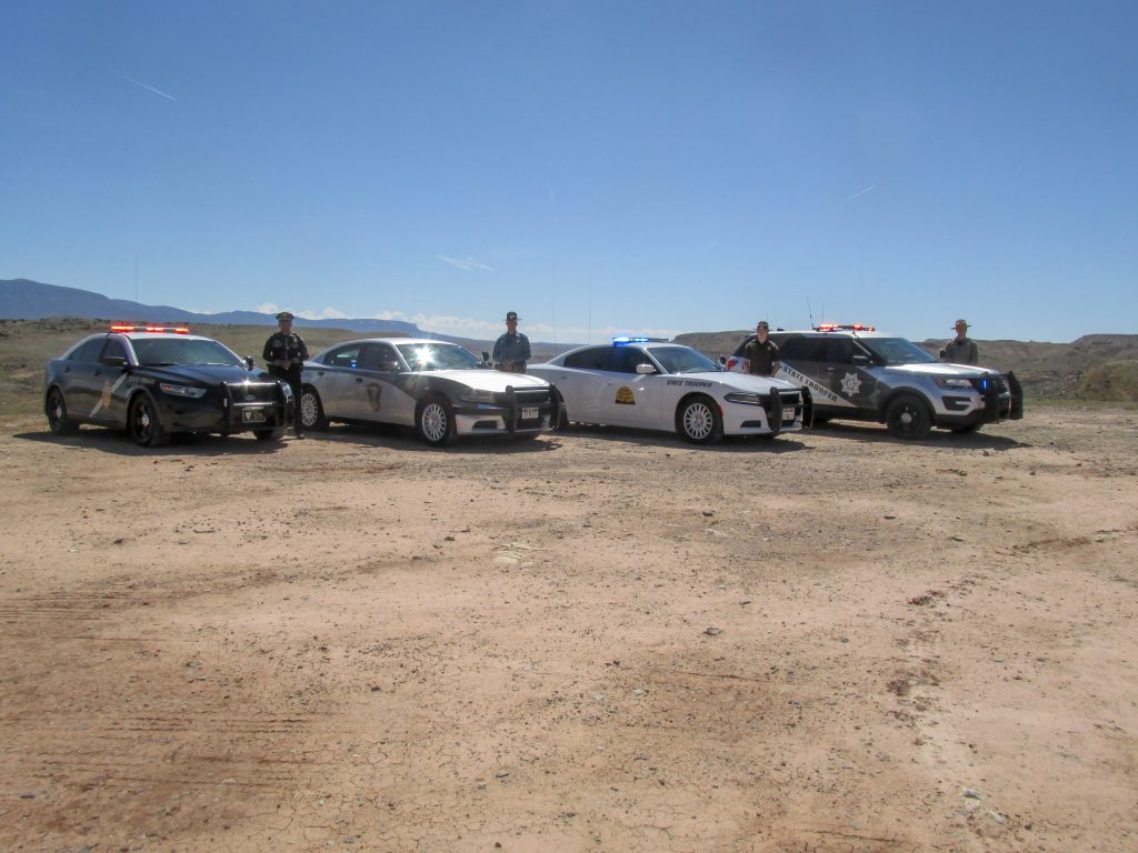 State troopers from New Mexico, Colorado, Utah and Arizona stand by their vehicles.