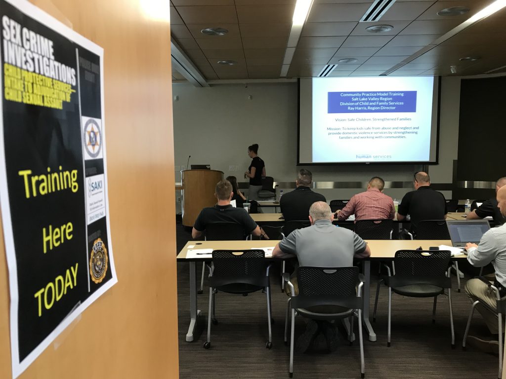 Nicole Nielsen from DCFS presents information to sex crimes investigators about the role of DCFS. She stands at the front of the class and officers sit at desks listening.