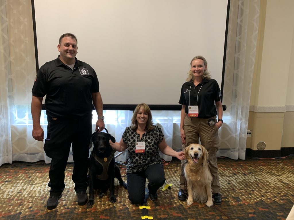 Cold Case Analyst Kathy Mackey appears with cadaver dogs Halo and Unita and their handlers, who are members of Fide Canem Cold Case Search and Recovery Dogs.