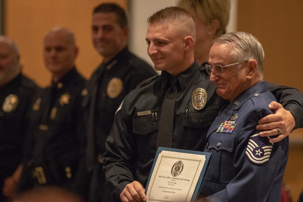 A graduating cadet poses with his grandfather as he accepts his law enforcement certificate.