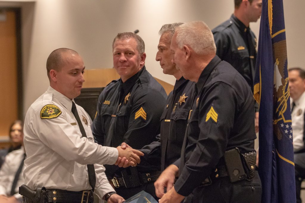 Utah County Deputy Volk shakes hands with Sgt. Watson after receiving the high academic award.