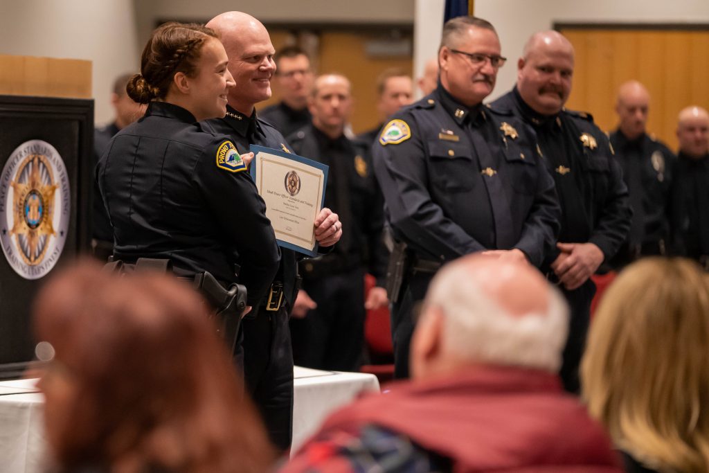 A new officer poses with her law enforcement certificate.