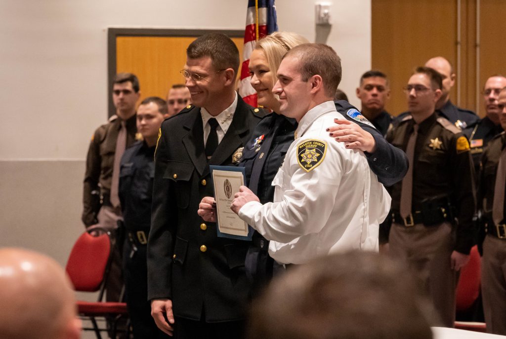 A new officer poses with his law enforcement certificate.