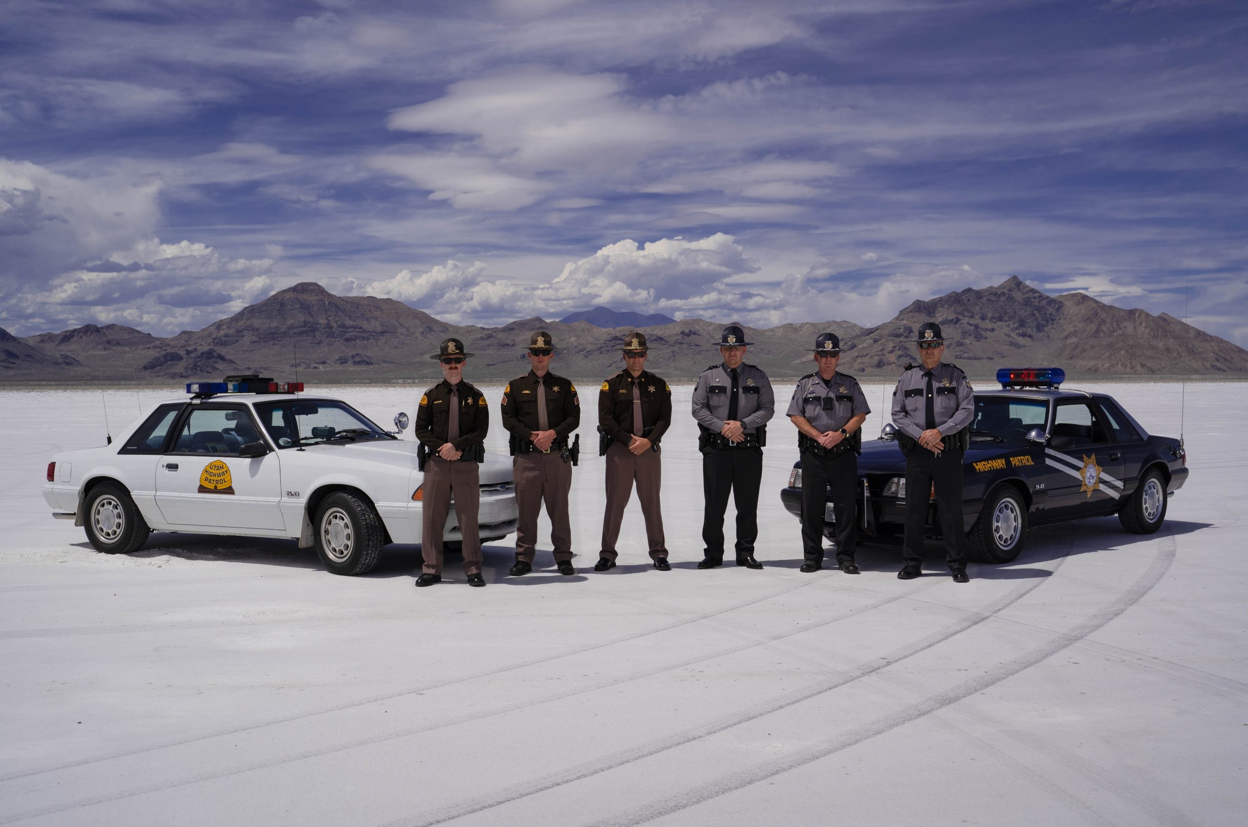 Three UHP Troopers and 3 Nevada Troopers stand by their vehicles on the Salt Flats.