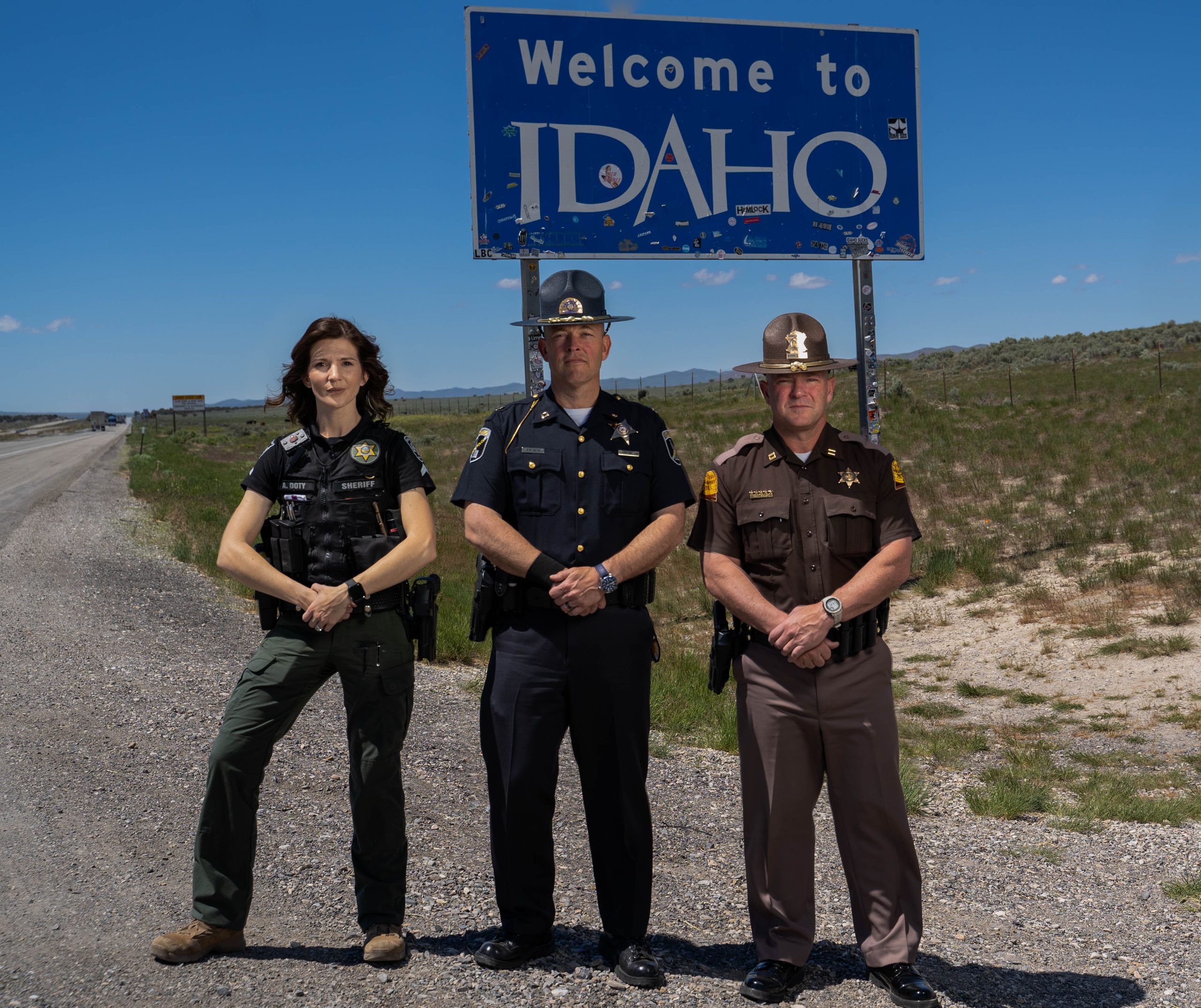 A Cassia County Deputy, ISP Captain and UHP Captain stand by the Welcome to Idaho sign.