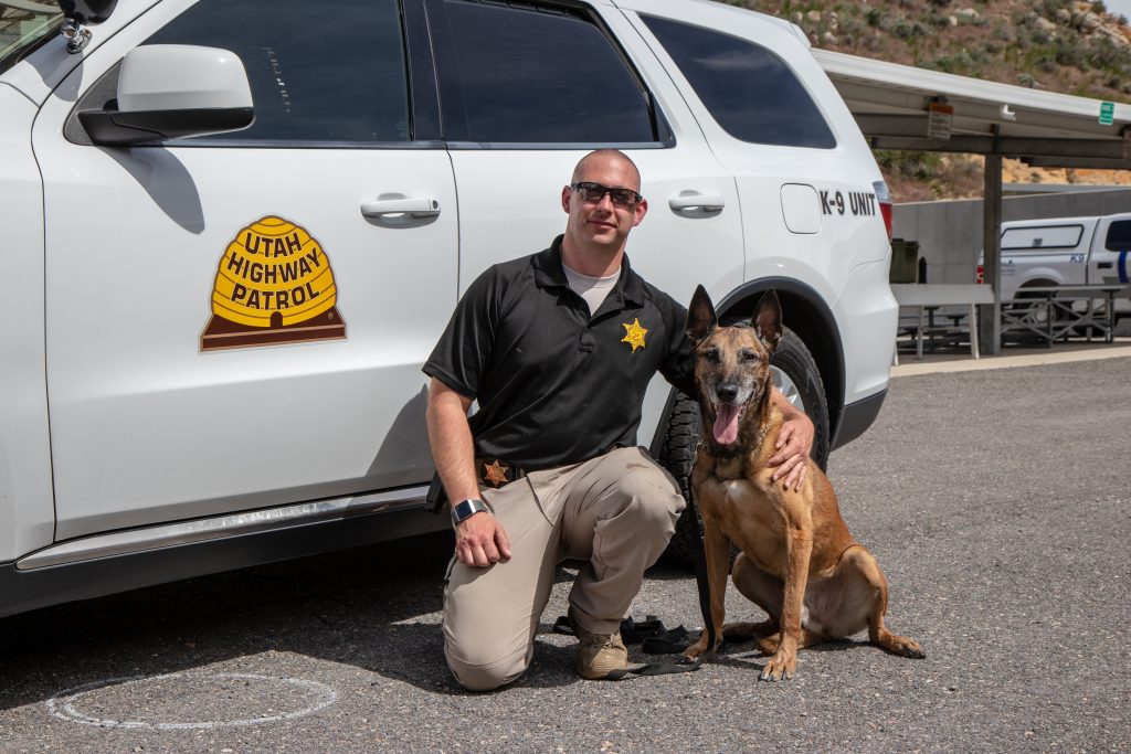 K9 Arros with handler Trooper Colvin pose by a UHP SUV