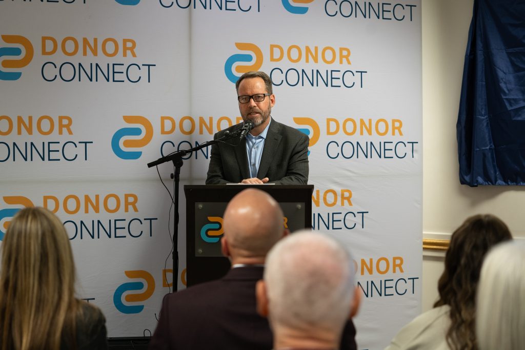 Brady Dransfield from DonorConnect speaks at the podium.