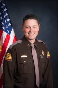 Jason Ricks is pictured in his UHP uniform in front of an American flag